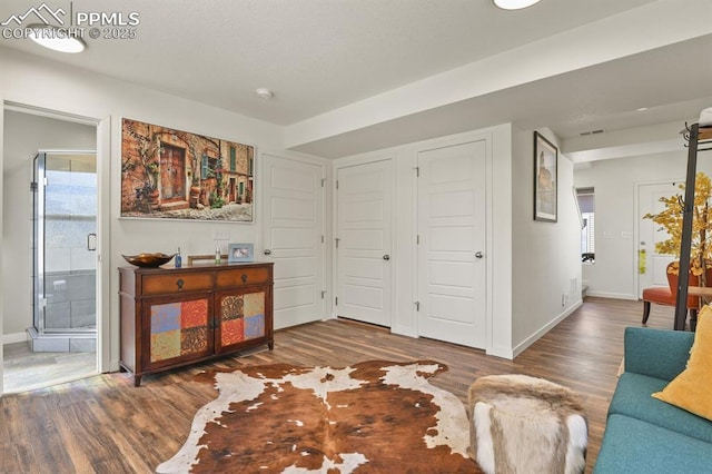 living area with wood finished floors, visible vents, and baseboards