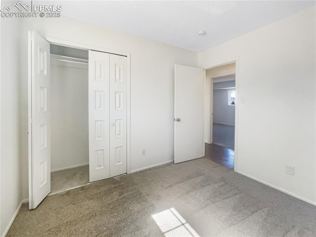 unfurnished bedroom with a closet, carpet, and baseboards