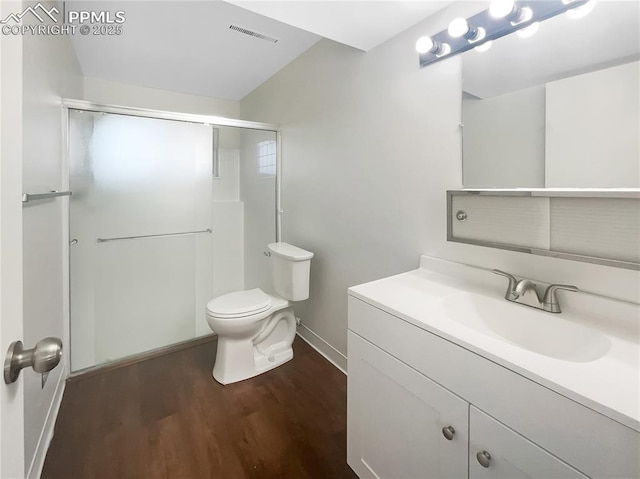 bathroom featuring visible vents, toilet, a stall shower, vanity, and wood finished floors