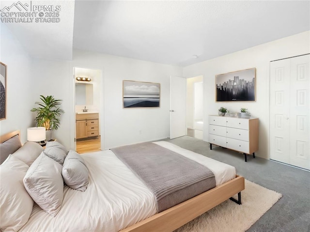 carpeted bedroom featuring a sink, a closet, and connected bathroom