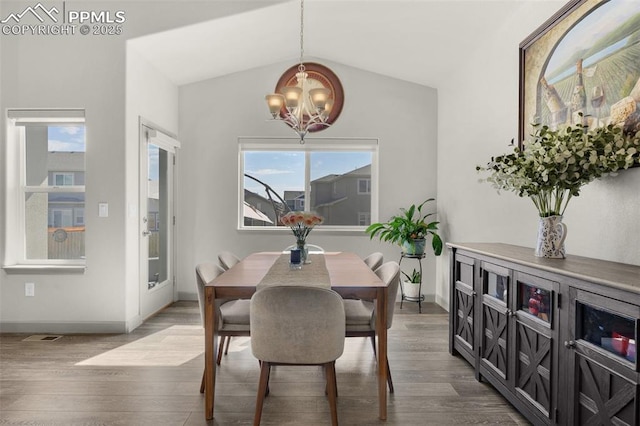 dining room with a notable chandelier, baseboards, lofted ceiling, and wood finished floors