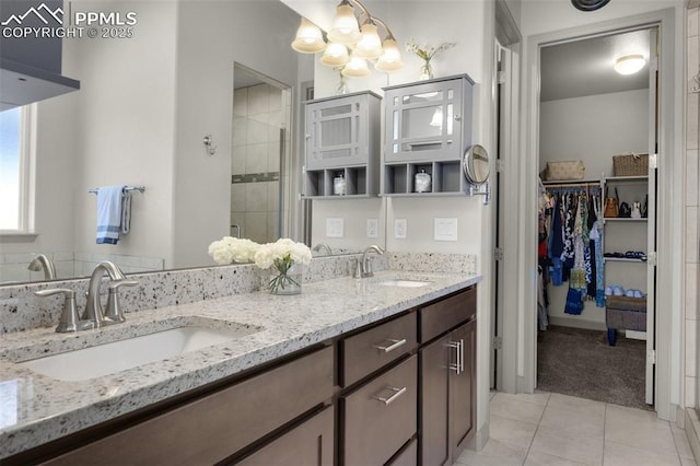 full bath with tile patterned floors, double vanity, a stall shower, and a sink