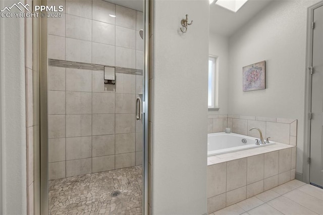 full bathroom with a stall shower, a skylight, a bath, and tile patterned floors