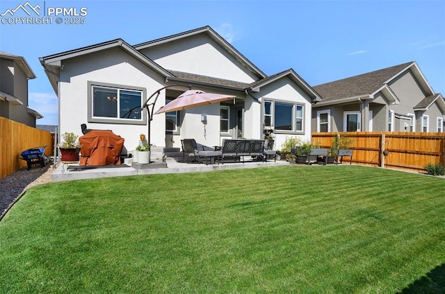 rear view of house with a patio area, a lawn, a fenced backyard, and stucco siding