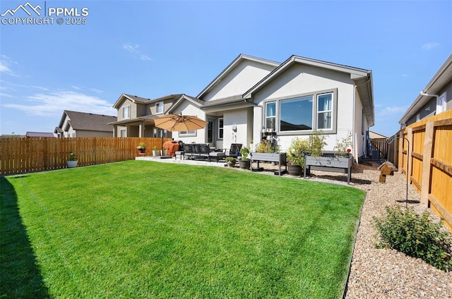 rear view of property with a fenced backyard, stucco siding, a yard, and a patio