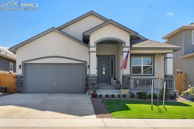 view of front facade featuring a front yard, driveway, an attached garage, stucco siding, and stone siding