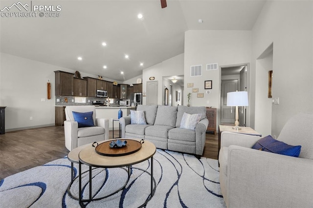 living area with recessed lighting, visible vents, high vaulted ceiling, and light wood finished floors