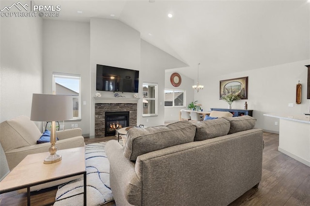 living area featuring baseboards, a fireplace, an inviting chandelier, wood finished floors, and high vaulted ceiling