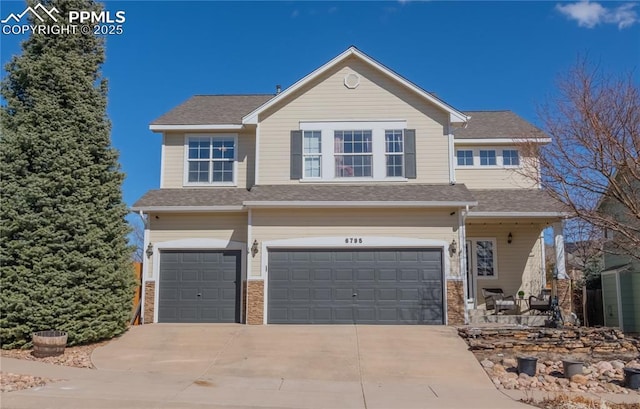 view of front of home featuring driveway, roof with shingles, and an attached garage