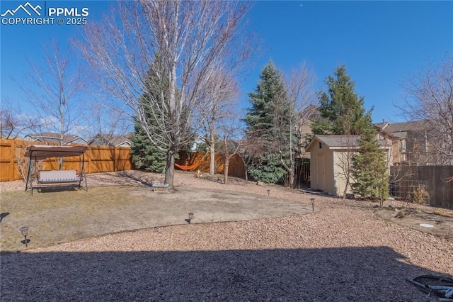 view of yard with a fenced backyard, a shed, and an outdoor structure