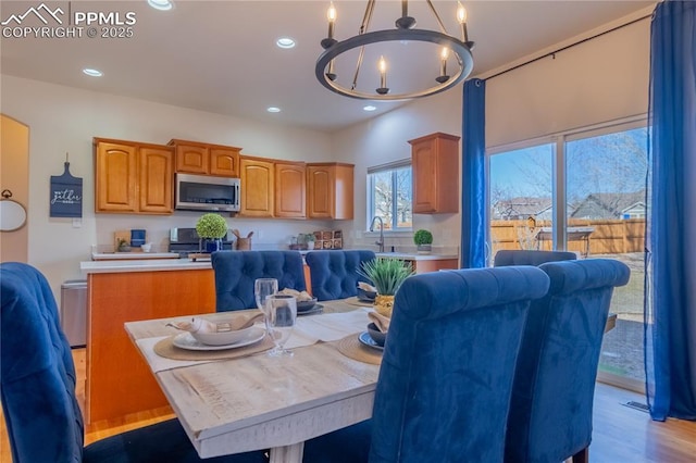 kitchen featuring appliances with stainless steel finishes, an inviting chandelier, light countertops, light wood-style floors, and recessed lighting