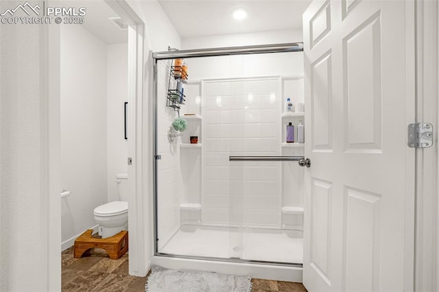 bathroom featuring toilet and a shower stall