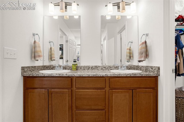 bathroom featuring double vanity, a sink, and a walk in closet