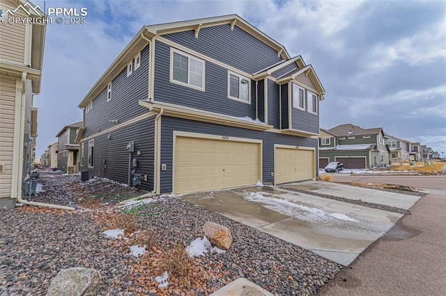 view of front of home with a garage, a residential view, and driveway