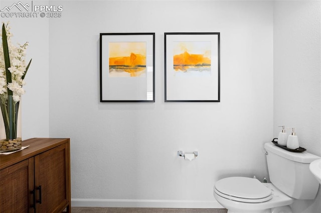 bathroom with baseboards, vanity, and toilet