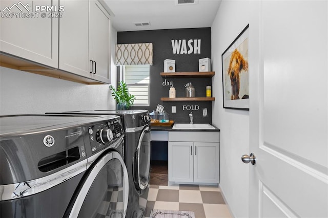 laundry area featuring cabinet space, visible vents, washer and clothes dryer, light floors, and a sink