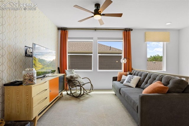 carpeted living area featuring wallpapered walls and ceiling fan