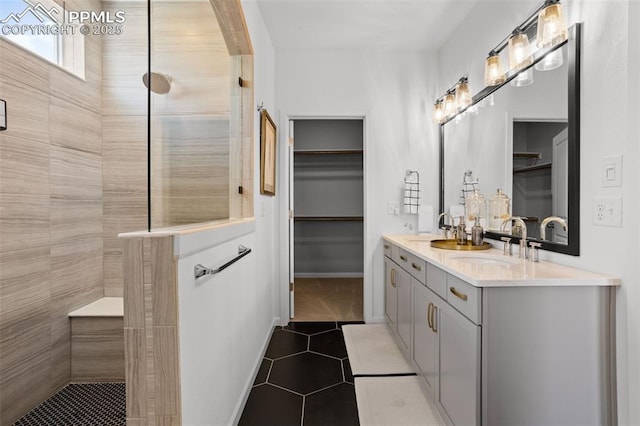 full bathroom with double vanity, a walk in shower, a sink, and tile patterned floors