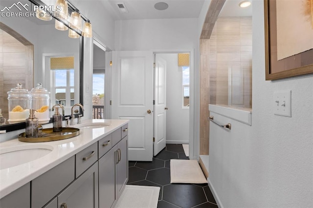 full bath featuring tile patterned flooring, visible vents, a sink, and double vanity