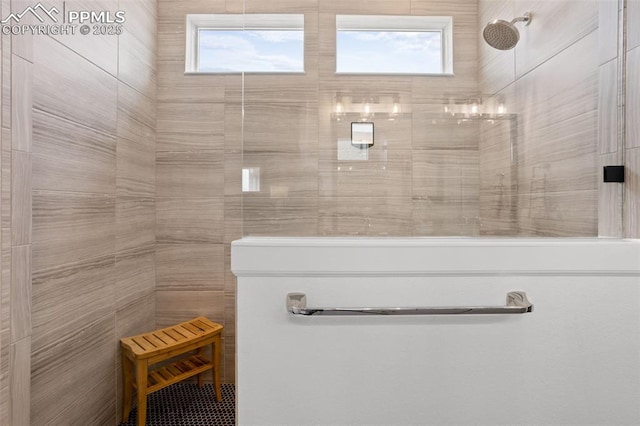 full bath featuring a healthy amount of sunlight and tiled shower