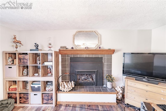 interior space with a textured ceiling, wood finished floors, and a fireplace