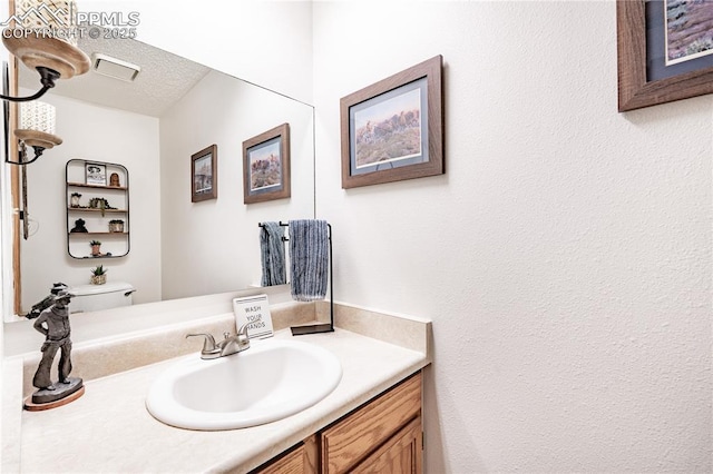 bathroom with a textured ceiling and vanity