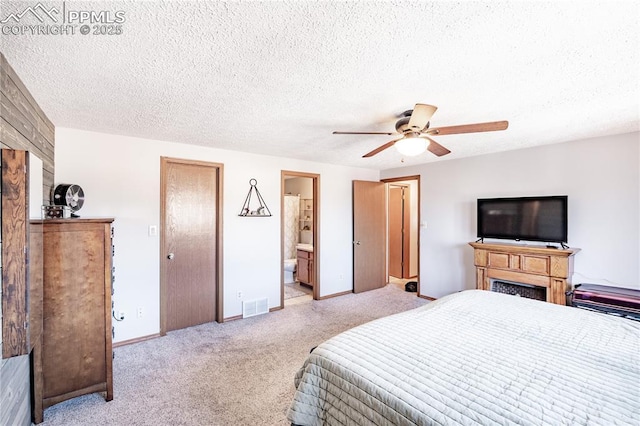 bedroom featuring visible vents, baseboards, light colored carpet, and a textured ceiling