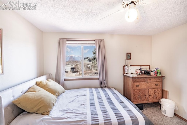 carpeted bedroom with a textured ceiling and a ceiling fan