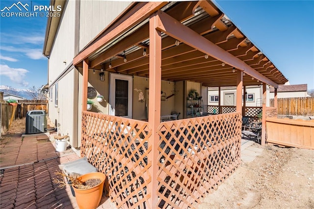 view of patio with central air condition unit and fence