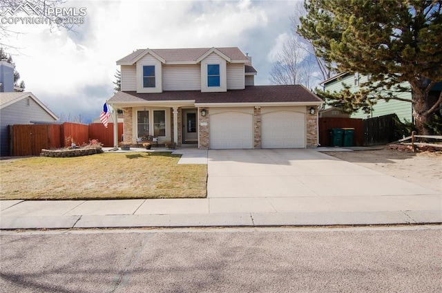 traditional home with a front lawn, fence, concrete driveway, a garage, and brick siding