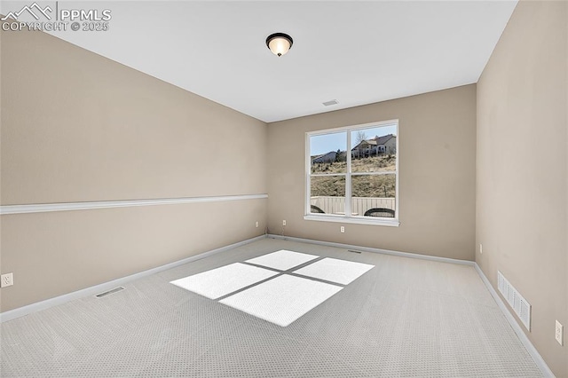 unfurnished room with carpet, visible vents, and baseboards