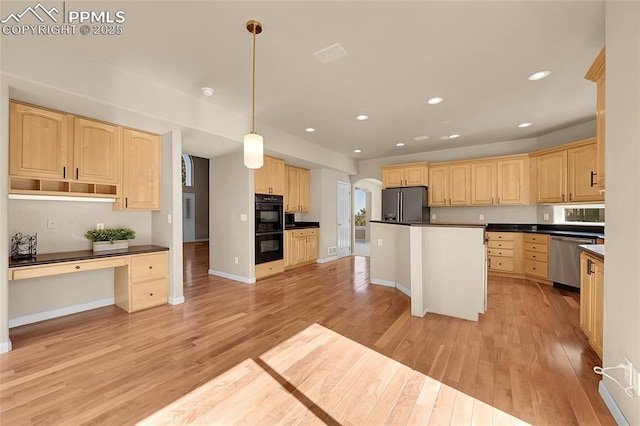 kitchen with light wood-style floors, dark countertops, black appliances, and light brown cabinetry