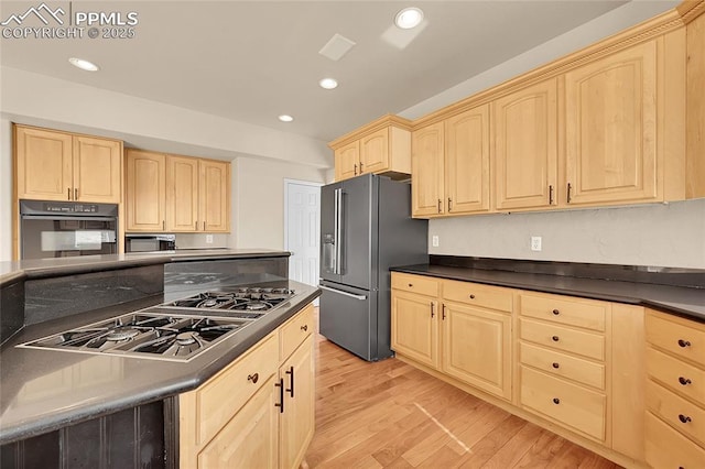 kitchen with dark countertops, light wood-style flooring, stainless steel appliances, and light brown cabinetry