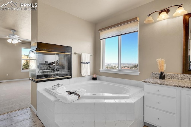 bathroom featuring ceiling fan, vanity, and a bath