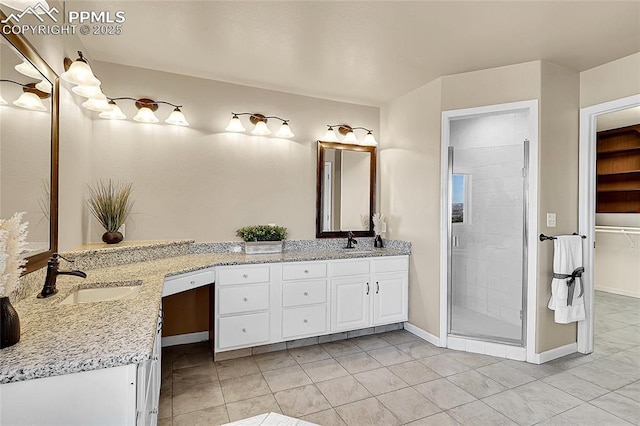 bathroom with a stall shower, baseboards, tile patterned floors, a spacious closet, and vanity