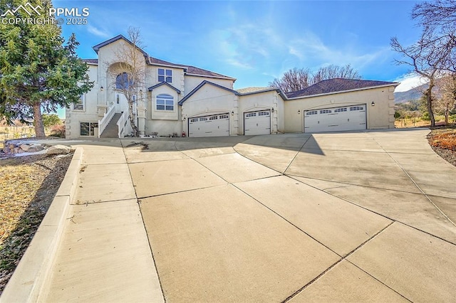 view of front of property with a garage, concrete driveway, and stucco siding