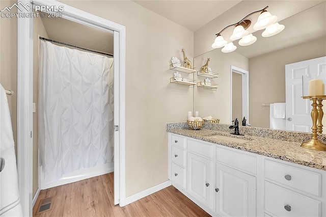 full bathroom featuring baseboards, visible vents, wood finished floors, and vanity