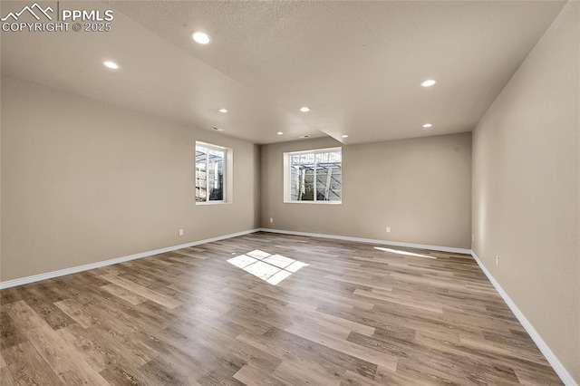 empty room with recessed lighting, wood finished floors, and baseboards