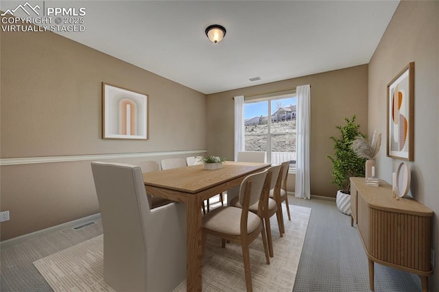 dining space featuring light colored carpet, visible vents, and baseboards