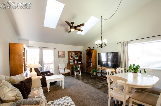 living area with high vaulted ceiling, ceiling fan with notable chandelier, a skylight, and wood finished floors