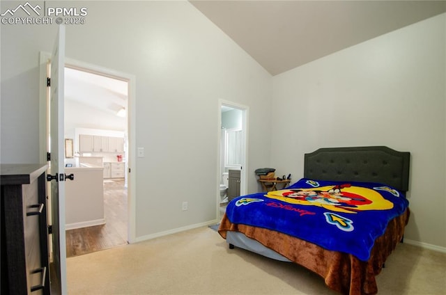 carpeted bedroom featuring baseboards, lofted ceiling, and ensuite bathroom