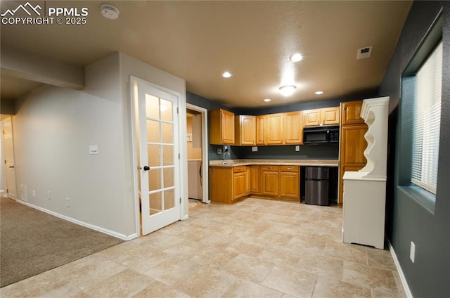 kitchen with visible vents, fridge, black microwave, light countertops, and baseboards