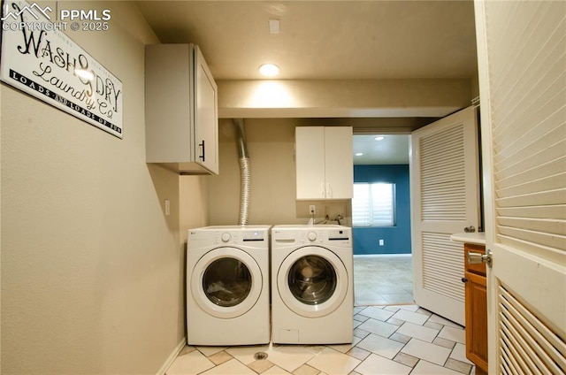 laundry room featuring washer and dryer, cabinet space, and baseboards