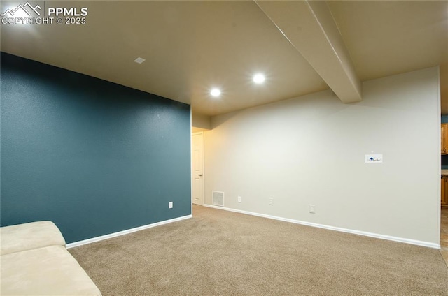 unfurnished room featuring beam ceiling, visible vents, baseboards, and carpet