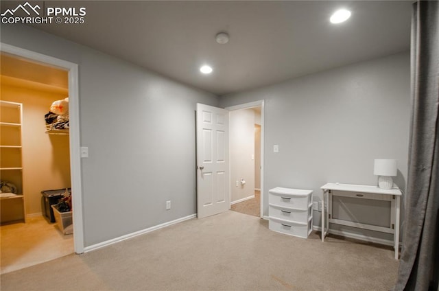 carpeted bedroom featuring recessed lighting, a walk in closet, and baseboards