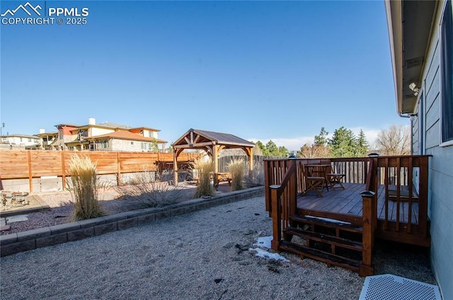 view of yard featuring a gazebo, a wooden deck, and fence