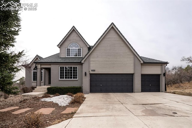 traditional home with a garage, driveway, and brick siding