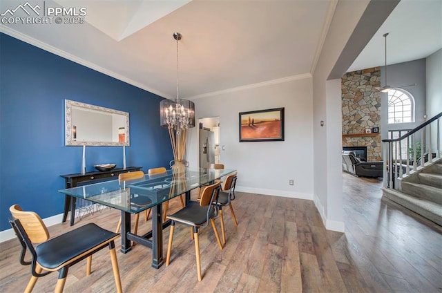 dining space featuring crown molding, stairway, an inviting chandelier, wood finished floors, and baseboards