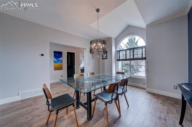 dining room with crown molding, visible vents, wood finished floors, a chandelier, and baseboards