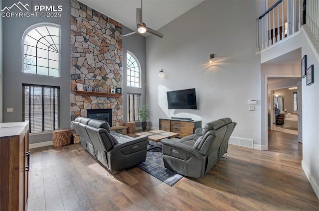 living area featuring plenty of natural light, a fireplace, wood finished floors, and visible vents